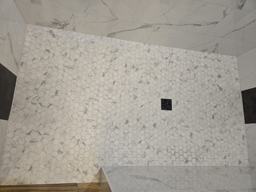 Pebble shower floor tile installation with square drain