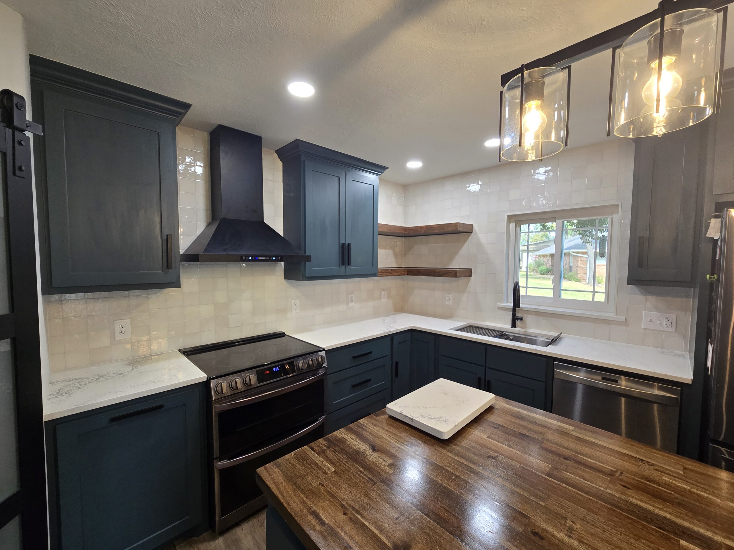 Kitchen tile backsplash installation with modern cabinetry and vent hood