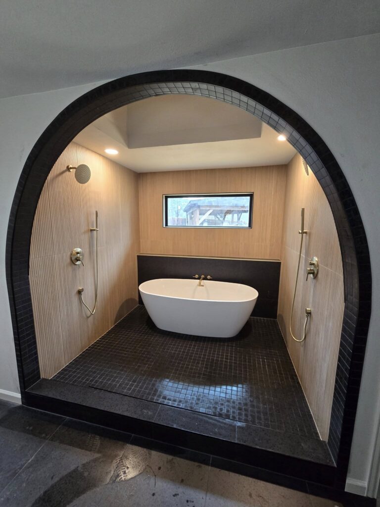 Luxury bathroom tile installation with freestanding tub and walk-in shower