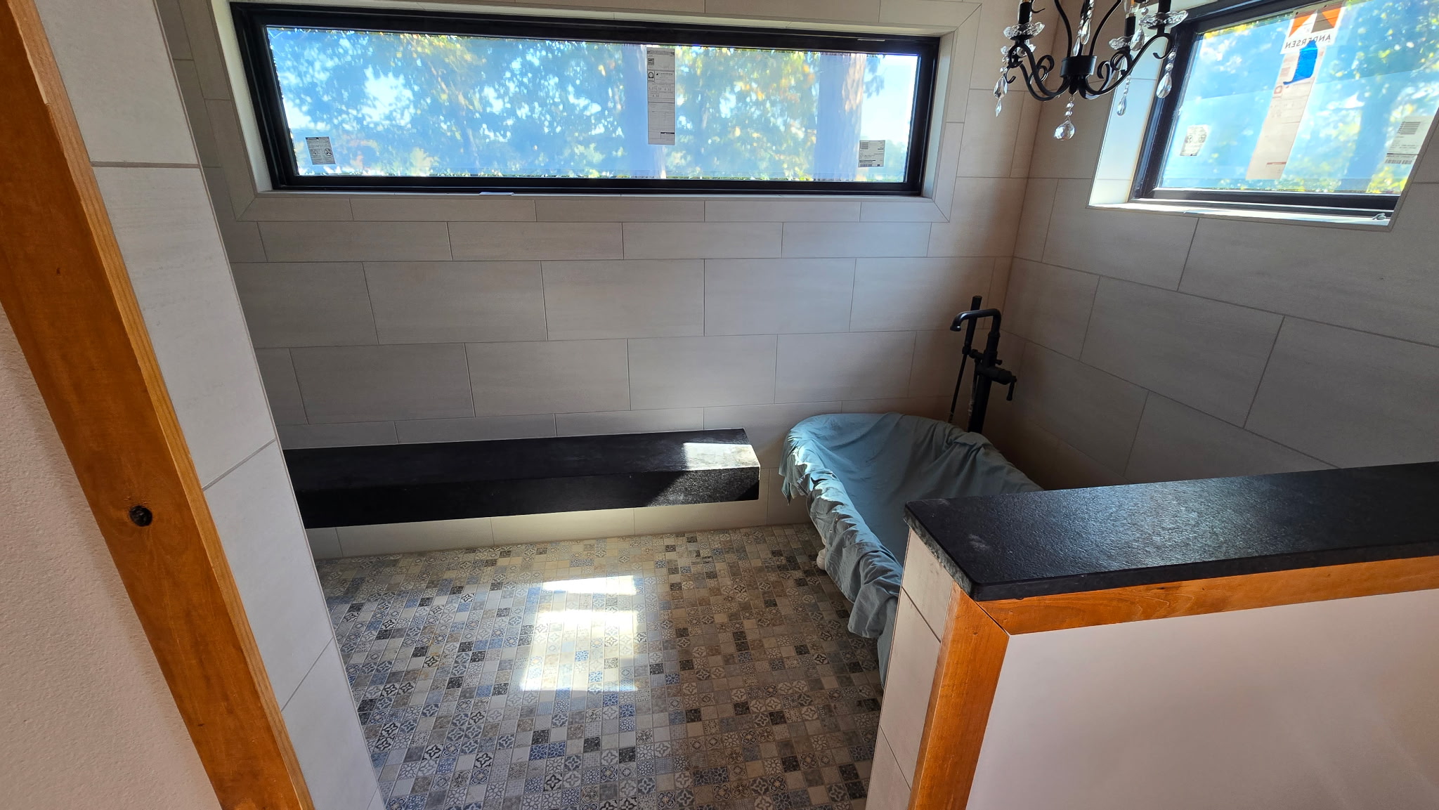 Custom walk-in shower tile installation with built-in bench and mosaic tile floor by JPond Custom Tile