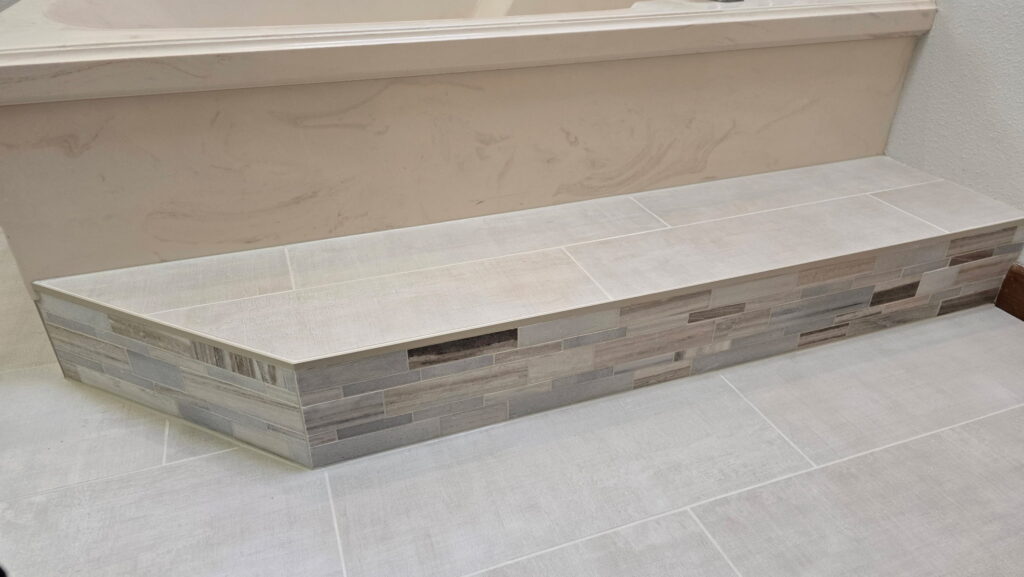 Custom bathroom bench tile installation with stone tile finish