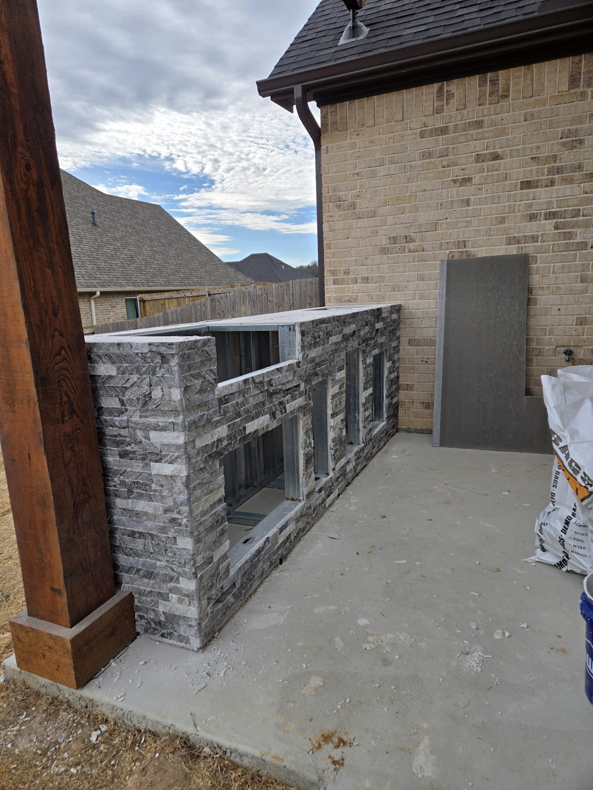 Outdoor stone fireplace tile surround installation by JPond Custom Tile Tyler TX