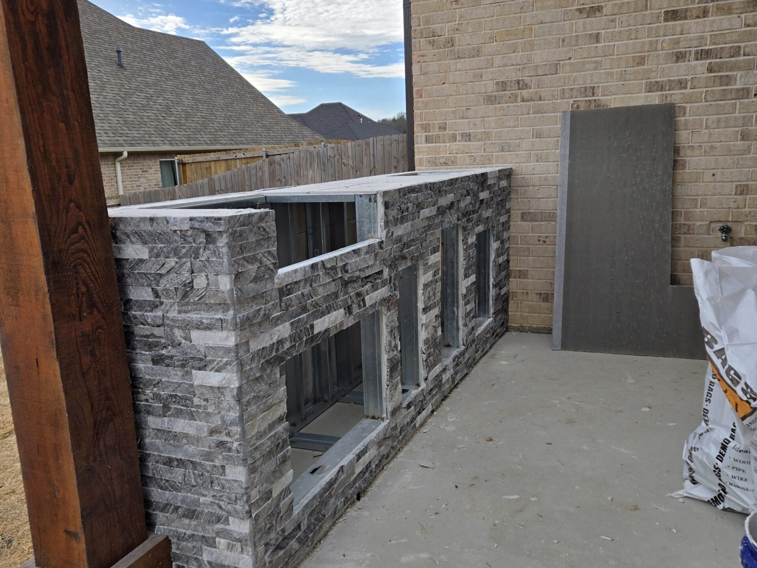 Outdoor stone fireplace tile surround installation by JPond Custom Tile Tyler TX