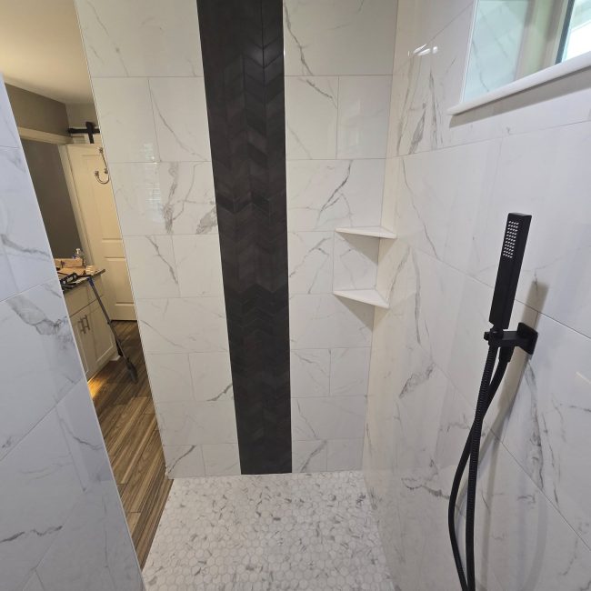 Large format marble shower tile installation with shower niche
